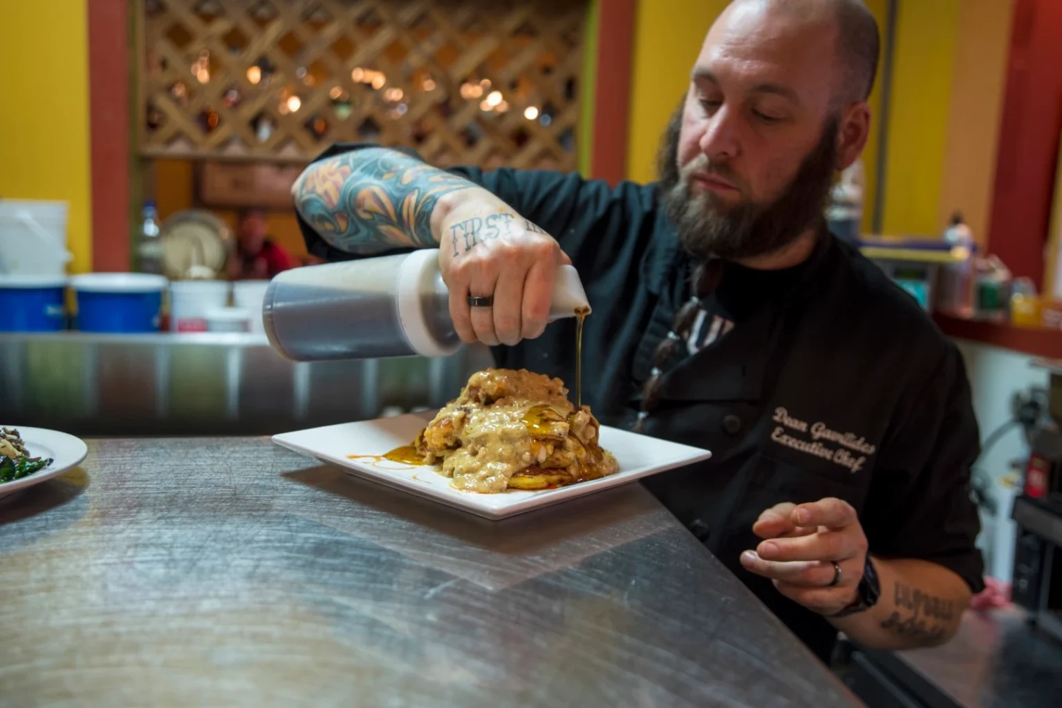 A Soup Spoon chef plating a dish in the kitchen
